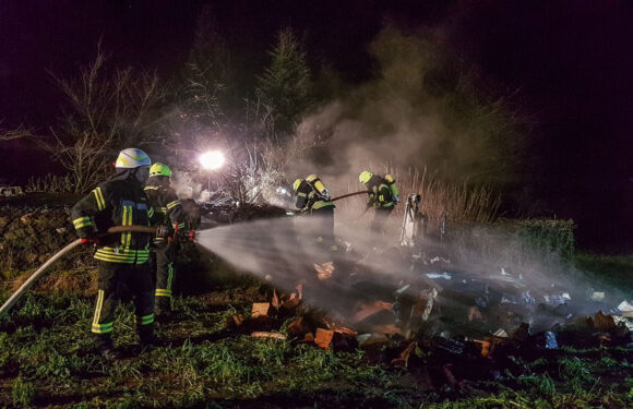 Feuerwehr löscht brennenden Holzhaufen in Scheie
