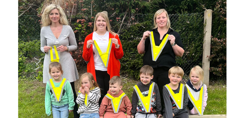 Damit Kinder besser gesehen werden: Volksbank spendet Sicherheitswarnkragen für Kita Straußweg